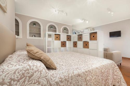 een witte slaapkamer met een bed en een stoel bij Shanti Home - Restaurant di Aversano Salvatore in Sorrento