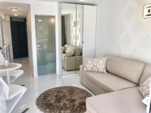 a living room with a couch and a mirror at Style Apartment with Ocean view in Playa de las Americas