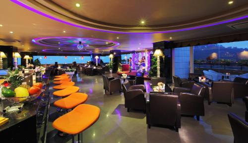 a restaurant with a bar with orange chairs and tables at Ha Long DC Hotel in Ha Long