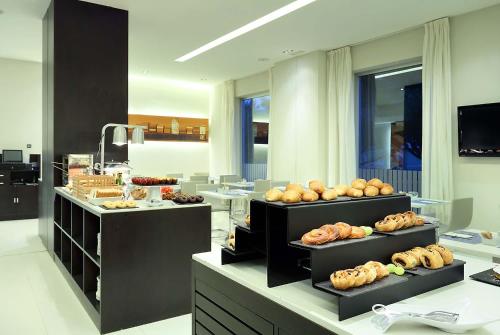 une boulangerie avec plusieurs étagères remplies de différents types de pain dans l'établissement Exe Puerto de Sagunto, à Puerto de Sagunto