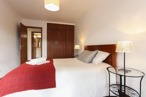 リスボンにあるModern Graca by Homingのベッドルーム(赤い毛布付きの白い大型ベッド1台付)