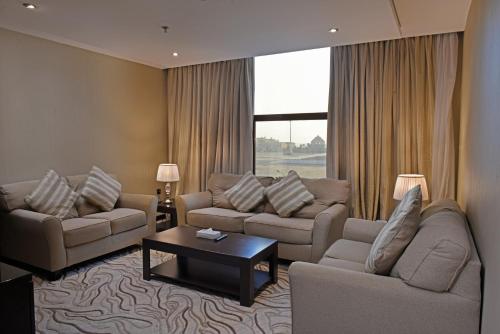 a living room with two couches and a coffee table at Naviti Warwick Al Khobar in Al Khobar