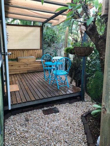 une terrasse en bois avec une table et des chaises. dans l'établissement SEA-green, à Nelly Bay