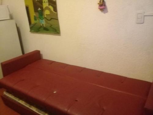 un sofá rojo en una habitación con una pintura en la pared en Depto San Bernardo céntrico sobre Costanera en San Bernardo