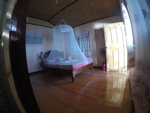 a room with a bed with a net at Coconut Garden Island Resort in San Vicente