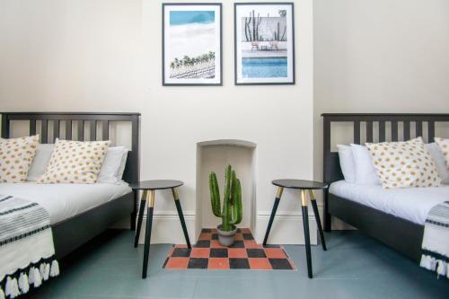 una sala de estar con 2 camas y un cactus en Brighton Lanes Townhouse, en Brighton & Hove