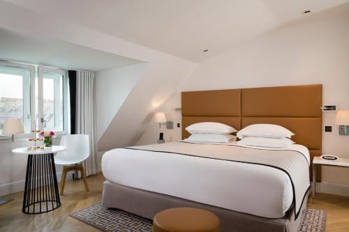 a bedroom with a large bed and a table at Hôtel R de Paris - Boutique Hotel in Paris