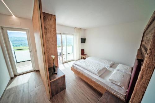 a bedroom with a bed and a large window at Residence Tannhof in Caldaro