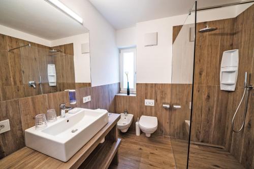 uma casa de banho com um lavatório e um WC em Residence Tannhof em Caldaro