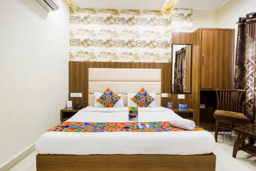 a hotel room with two beds and a chair at FabHotel Royal Villa Hussainpura Chowk in Amritsar