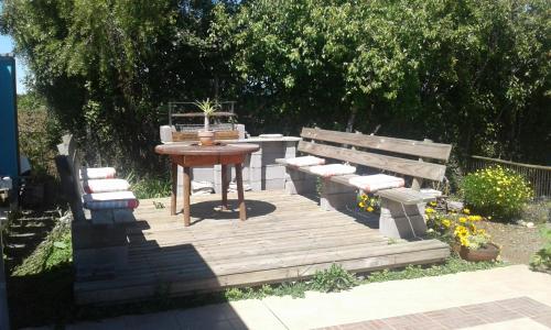 a wooden deck with a table and a table and benches at Hostal La Maravilla in Vilches