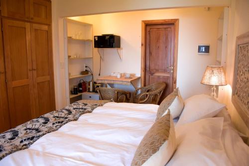 um quarto com uma grande cama branca e uma secretária em ALEHUE Casa de Montaña em Villa La Angostura