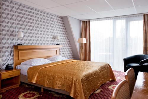 een hotelkamer met een bed en een stoel bij Hotel Restaurant Boschlust in Oudemirdum