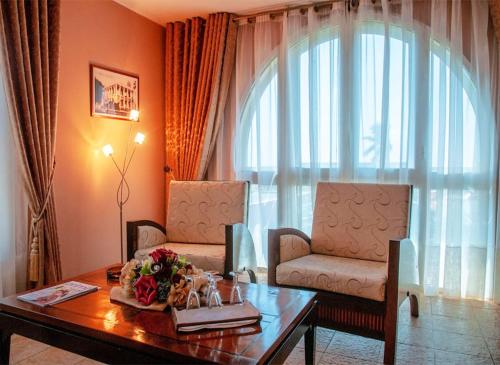 a living room with a table and a chair at Le Grand Hôtel Diego in Diego Suarez