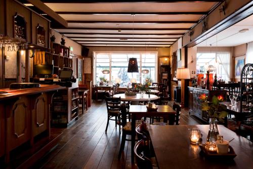 een restaurant met tafels en stoelen in een kamer bij Hotel Restaurant Boschlust in Oudemirdum