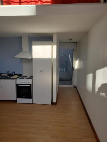 a kitchen with white appliances and a wooden floor at Lugones in Ezeiza