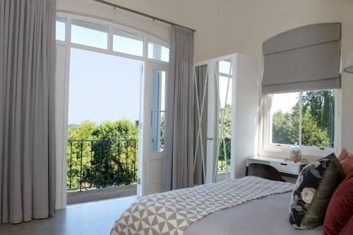 a bedroom with a bed and a large window at Le Vine Constantia in Cape Town