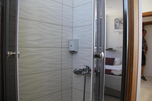 a shower with a glass door in a bathroom at AELBİSTAN OTEL in Didim
