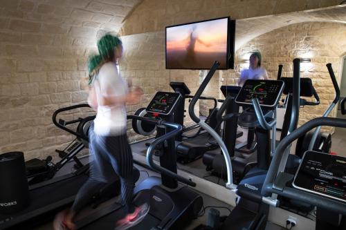 a woman running on a treadmill in a gym at Hôtel R de Paris - Boutique Hotel in Paris