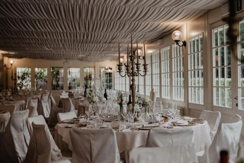 a banquet hall with white tables and white chairs at Hotel Villa Condulmer in Mogliano Veneto