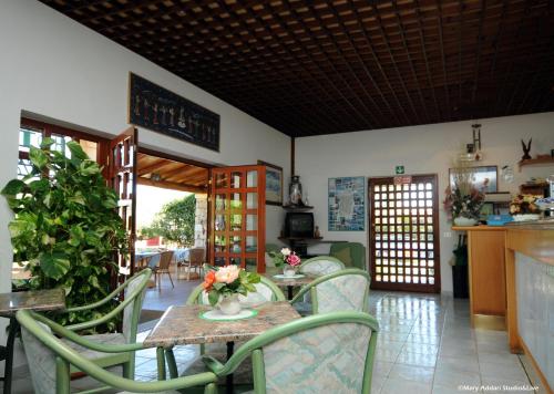 uma sala de jantar com mesa e cadeiras em Hotel Villa Gemella em Baja Sardinia