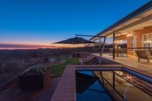 a house with a swimming pool and a patio at Rockfig Lodge Madikwe in Madikwe Game Reserve