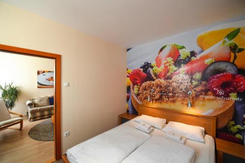 Una cama o camas en una habitación de Imola Udvarház Dessert Hotel