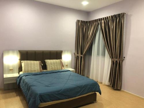 a bedroom with a bed and a window with curtains at Meena's Apartment @ The Quintet in Cameron Highlands