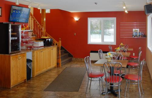 a kitchen with red walls and a table and chairs at Hotel Robin Hood in Grand Falls