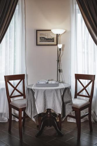 a table with two chairs and a lamp in a room at Ekaterinoslav in Dnipro