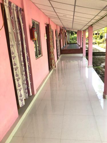 a hallway of a pink building with a tile floor at Blue Bird Residency in Neil Island