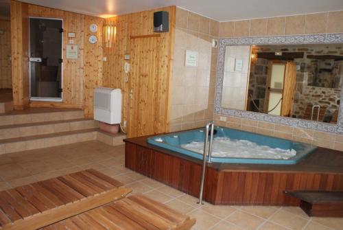 un ampio bagno con vasca e specchio di Auberge La Tomette, The Originals Relais a Vitrac