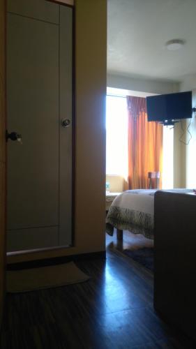 a bedroom with a bed and a sliding glass door at Hostal Inca in San Pedro