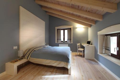 a bedroom with a bed and a desk in it at Zoncolan Apartments in Sùtrio