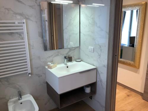 a bathroom with a sink and a mirror and a toilet at Relais Dei Mandorli in Bergamo
