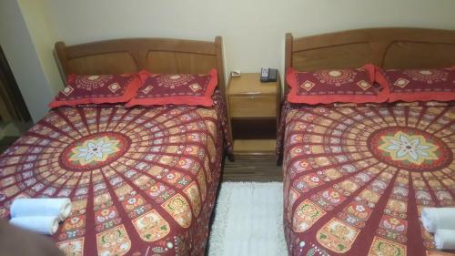 two beds sitting next to each other in a room at Hostal Inca in San Pedro