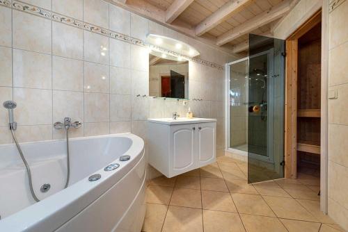 a bathroom with a tub and a shower and a sink at Ferienhaus Sprottenkiste in Baabe