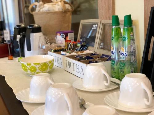 a counter with plates and cups and a coffee maker at Hotel Ontiveros in San Fernando