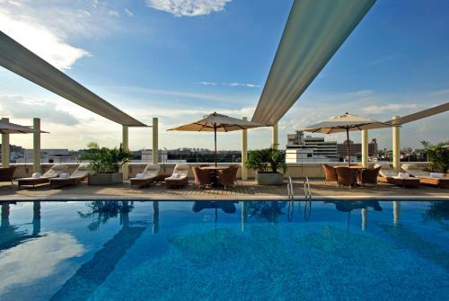 a large swimming pool with a balcony overlooking the ocean at Taj Club House in Chennai