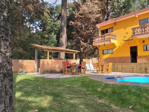 a house with a patio and a swimming pool at Hotel Villas Monteli Suites Cuernavaca in Cuernavaca