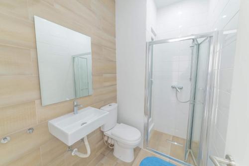 a bathroom with a toilet and a sink and a shower at Victoria Flats in Senglea