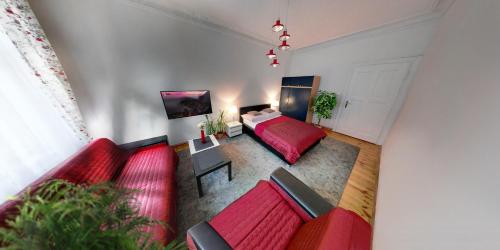 a living room with a red couch and a bed at Havana in Wrocław