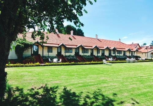 ein großes Gebäude mit Rasen davor in der Unterkunft Savoy - IHCL SeleQtions in Udagamandalam
