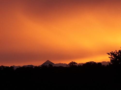 a sunset with a mountain in the background at Tropical Paradise Bungalows in Pital