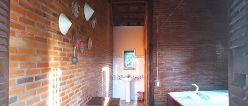 Quan TomにあるCat Tien Farmer Lodgeのレンガの壁と尿路が特徴のバスルーム