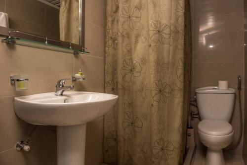 a bathroom with a sink and a toilet and a mirror at Megim Hotel in Palaiochora
