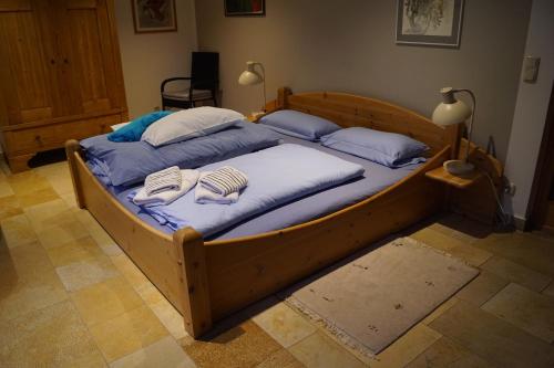 a large wooden bed with two pillows on it at Hamburg-Rahlstedt, klein aber sehr fein, ILS-nah in Hamburg