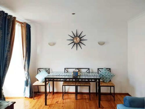 ein Wohnzimmer mit einem Tisch und Stühlen sowie einer Uhr an der Wand in der Unterkunft Lisbon Baixa 208 Apartment-Chiado in Lissabon