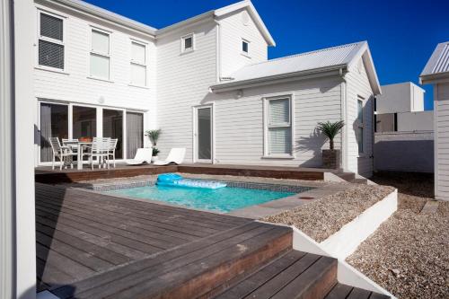 a house with a swimming pool in front of a house at Thyme & Tide Beach Villa in Yzerfontein