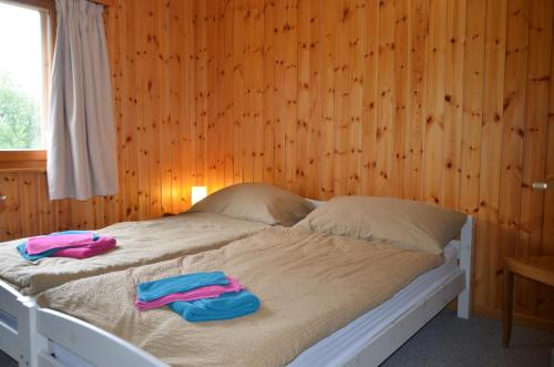 two towels on a bed in a room with wooden walls at Immeuble Les Sérandes in Les Collons